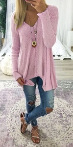 Close-up of pink V-neck waffle knit sweater with long sleeves and casual fit on model