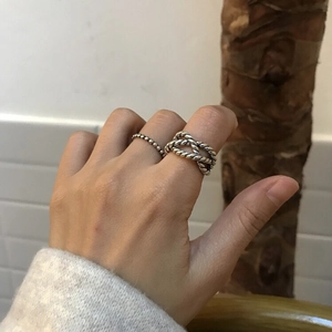 Detail of vintage 925 silver twist rope ring and beaded band worn on a hand