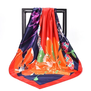 Detailed view of square satin scarf with vibrant floral patterns and silky gloss finish