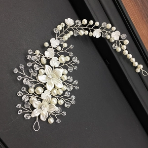 Detail showing handmade bridal headpiece with white flowers, pearls and crystals on silver wire