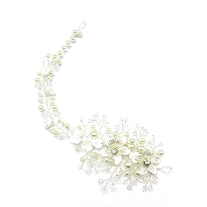 Detailed view of bridal hair vine with silver flowers, pearls, and crystals on white