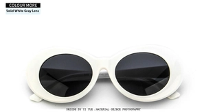 Flat lay of oval white frame sunglasses with dark grey lenses and a classic retro design