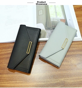 Detailed view of long envelope wallets with lychee pattern leather and gold metal accents