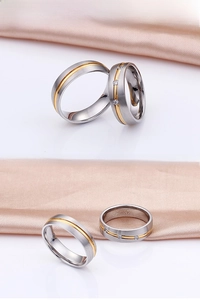 Close-up of two-tone stainless steel couple rings with three inlaid cubic zirconia stones
