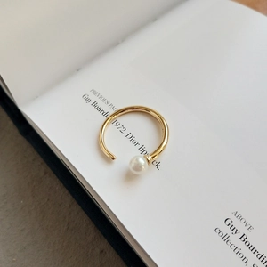 Minimalist 925 silver gold plated open ring with large white pearl on book background