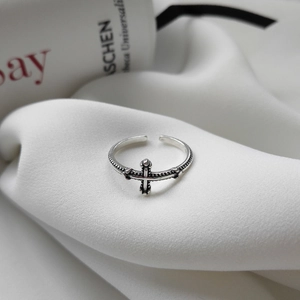 Vintage S925 sterling silver twisted cross open ring with oxidized finish on white fabric