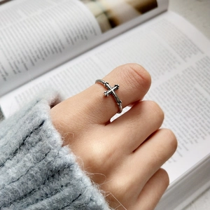 Vintage S925 sterling silver cross ring worn by a model over an open book backdrop