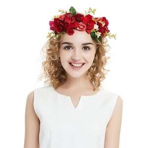 Detail of red and pink velvet rose hair clip with green leaves worn by a model