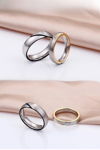 Detailed view of brushed stainless steel couple rings with zircon inlays and color accents