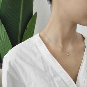 Minimalist S925 sterling silver opal pendant necklace worn on neck with green leaf background