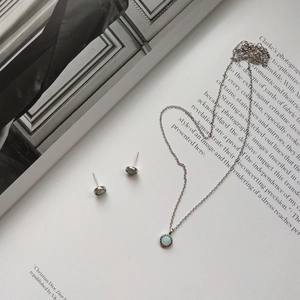 Detail of s925 sterling silver necklace and stud earrings set with iridescent round opal
