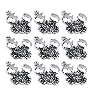 Detailed view of silver crab-shaped alloy charms with textured shell and hanging ring loop
