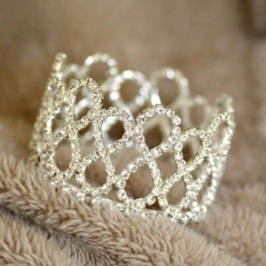 Close-up of vintage silver crown accessory with rhinestones on brown plush fabric