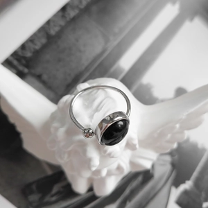 Macro view of vintage silver ring with black onyx stone and pink rhinestone detail