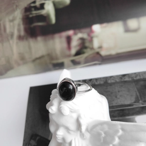 Detail of vintage 925 sterling silver ring with oval black onyx set on a white statue