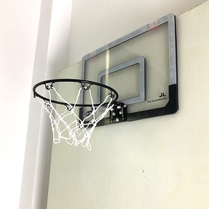 Detail of indoor mini basketball hoop with transparent backboard and metal rim on wall