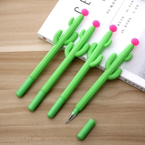 Macro detail of cactus gel pens with pink flower caps on a white magazine background