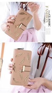 Close-up of khaki leather long wallet featuring leaf cutout and metal leaf pendant