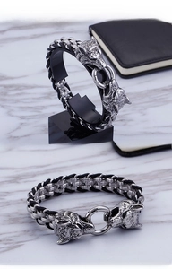 Detailed macro view of woven steel wolf head bracelet with intricate carving on marble base