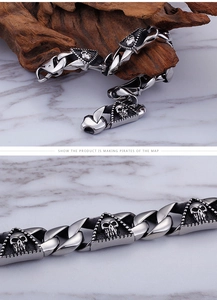 Macro shot of silver stainless steel skull bracelet links over a wooden and marble surface