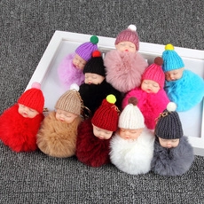 Collection of colorful sleeping baby plush ball keychains with assorted knit hats and fur poms