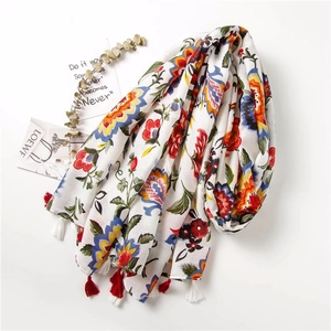 Close-up of vintage floral print scarf with long red and white tassels for women