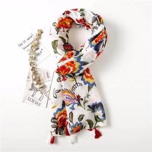 Detail of floral print scarf with vibrant flower patterns and decorative fringe trim