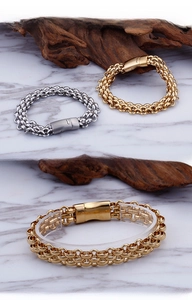 Detail of woven stainless steel men's bracelet with polished magnetic clasp in gold and silver