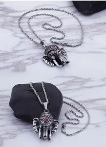 Detailed close-up of retro elephant pendant with red ruby inlay and twisted rope chain