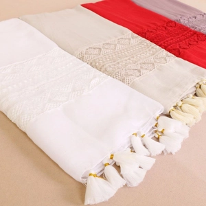 Detail showing lace embroidery and tassel fringes on lightweight multi-color shawls