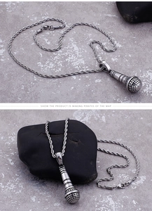 Macro shot of silver microphone pendant with textured mesh head on twist chain