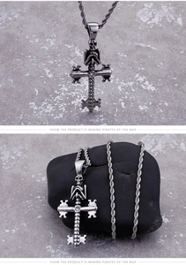 Detailed view of stainless steel skull cross pendant on a dark stone texture background
