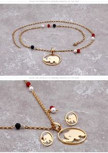 Détail du pendentif éléphant doré et des boucles d'oreilles avec perles rouges et noires