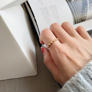 Primo piano di un sottile anello in argento S925 dorato con zirconi sulla mano