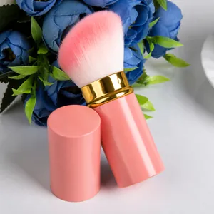 Retractable pink makeup brush with soft gradient bristles and matching protective cap