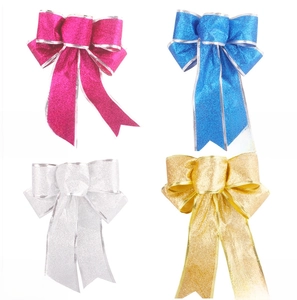 Close-up of glitter fabric Christmas bows in rose red, blue, silver, and gold colors
