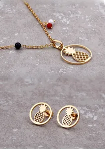 Detail of pineapple jewelry set with golden pendant and colorful beaded necklace