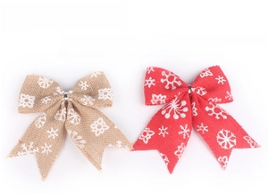 Detail of handmade red and tan burlap Christmas bows featuring printed white snowflakes