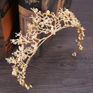 Couronne de mariée baroque dorée avec fleurs en strass et libellules sur livres anciens