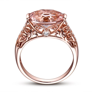 Detail of rose gold ring with large pink gemstone and intricate filigree hollow patterns
