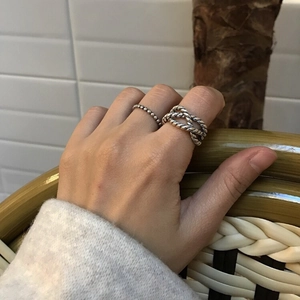 Detail of 925 sterling silver beaded and twisted rope ring set worn on finger