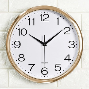 Detalle de reloj de pared metálico con marco dorado y números de cuarzo precisos
