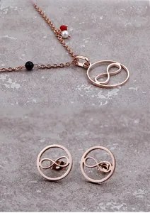 Detail eines roségoldenen Unendlichkeits-Schmucksets mit dekorativen farbigen Perlen
