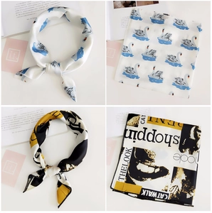 Detail of silk-like square scarf featuring elegant swan and modern letter print designs