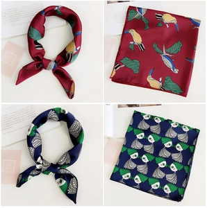 Detail of silk satin scarves featuring toucan prints and abstract patterns in various styles