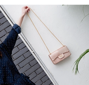 Close-up of champagne gold crossbody bag with V-shaped chevron texture and chain
