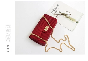 Detailed top view of a matte burgundy jelly bag with V-pattern and gold chain strap