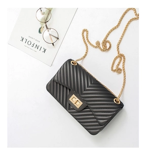 Detail of black V-quilted crossbody bag with golden chain strap and twist lock