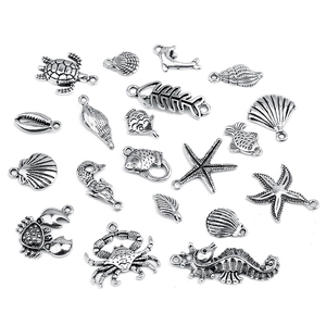 Flat lay of silver ocean-themed alloy charms including starfish and turtles for DIY crafts