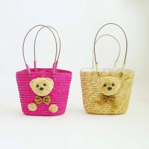 Detalle de bolsos de paja rosa y caqui con lindos ositos 3D para la playa de verano